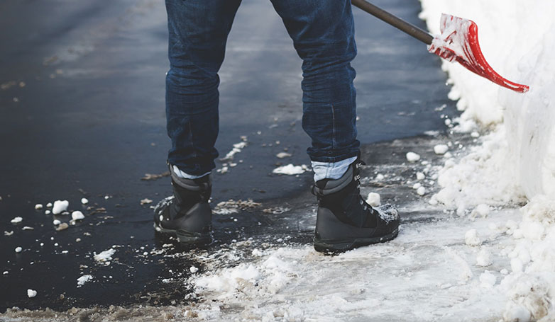 shoveling snow on asphalt surface