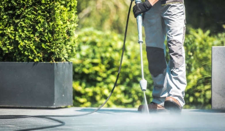 Concrete patio cleaning with a pressure washer. 
