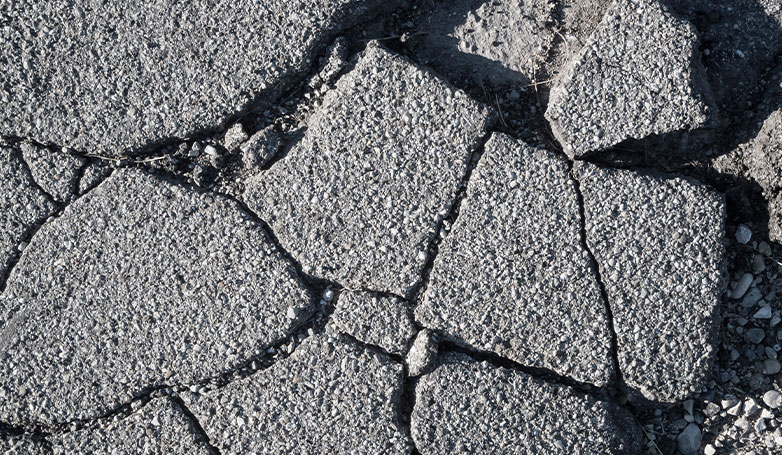 Image shows there has a crack on asphalt with some gravel