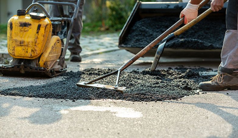 installing asphalt over the gravel driveway