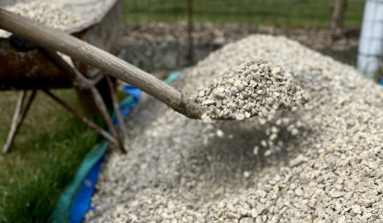 This image shows the gravel getting with the shovel by the worker.