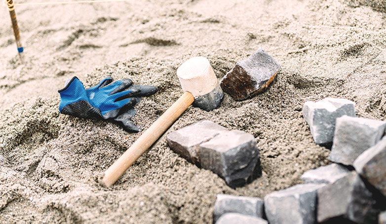This image shows the sand with tools and rocks on top.
