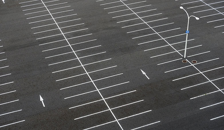 The clean asphalt parking lot with nice painted lines.
