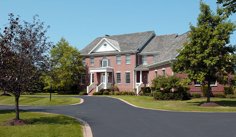 A sunny day on the beautiful house with smooth asphalt driveway