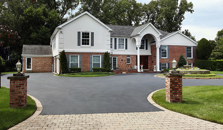 A beautiful house with clean and smooth tar and chip driveway.
