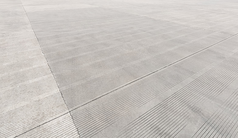 A concrete parking lot with design lines