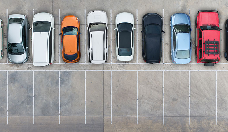 Different cars parked on concrete parking lots.