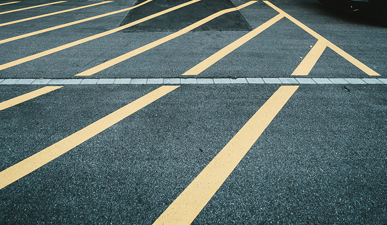 An asphalt parking lot with striping and drainage system.