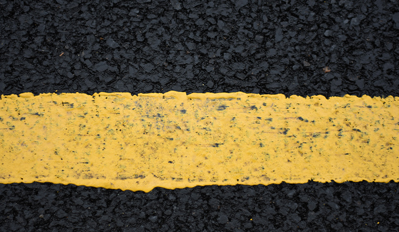 An asphalt roads with a yellow paint lane