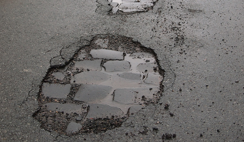 There has a water in potholes on asphalt roads