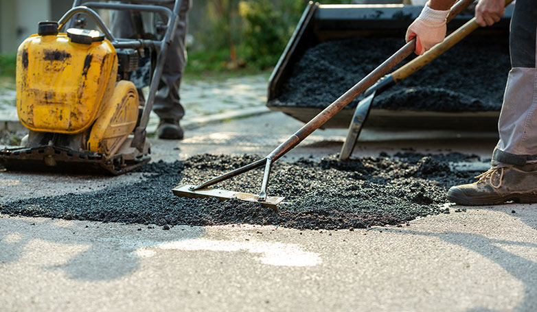 A workers busy on repairing asphalt driveway in a cold weather