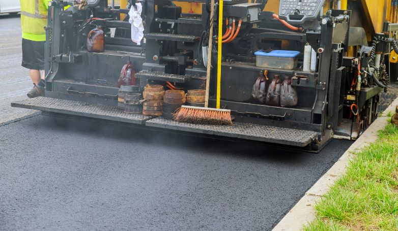 The worker is paving the asphalt road