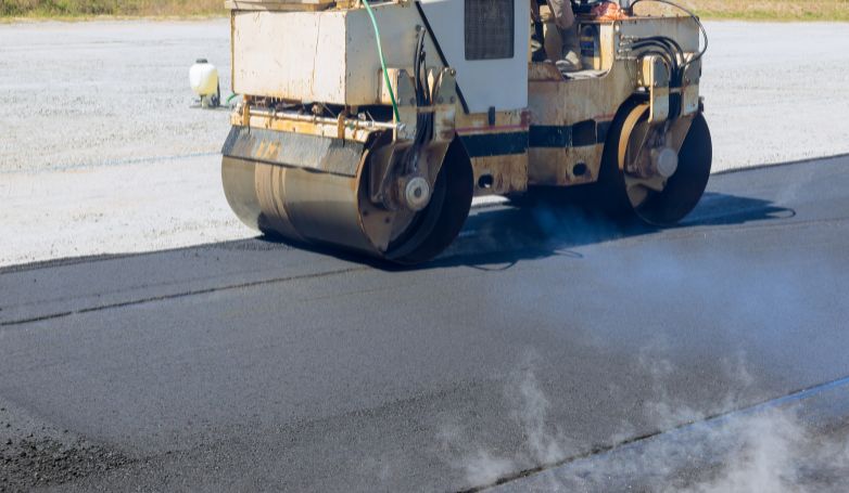 workers are applying a specific type of asphalt for a rough road