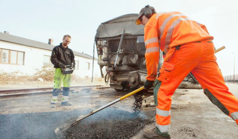The team of workers is applying the porous asphalt