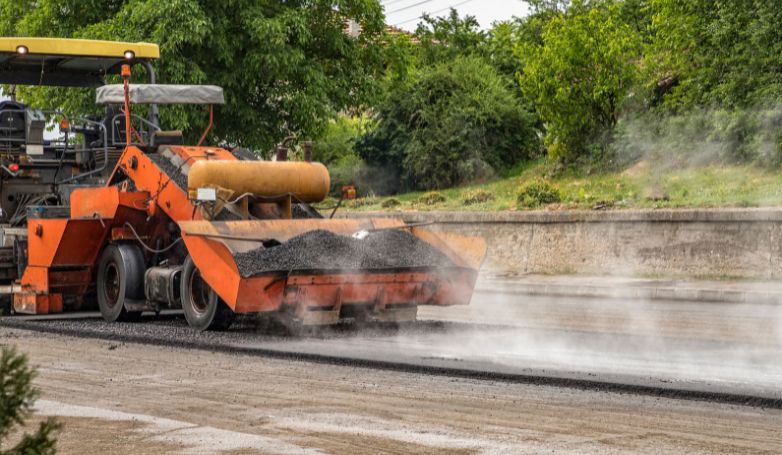 The machine is spreading Warm Mix Asphalt, an excellent type of asphalt, on the road