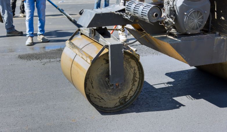A roller is used to smooth out the asphalt on the road well