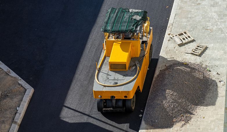 A roller is flattening freshly poured recycled asphalt