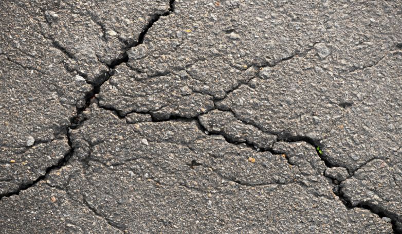 Workers repaired cracks in the asphalt before it was painted