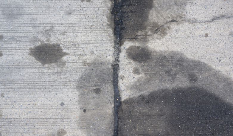 An asphalt driveway stained with car engine oil