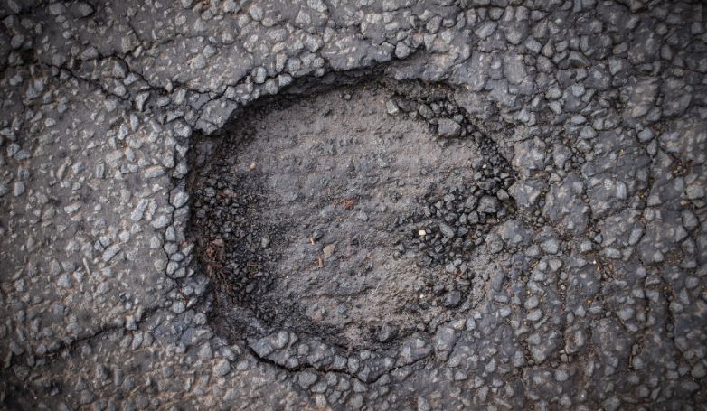 A big pothole in the parking lot surface